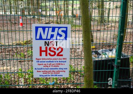Aylesbury Vale, UK. 9th April, 2021. An NHS not HS2 sign in the woods. HS2 were back in the ancient woodland of Jones Hill Wood today felling trees. Environmental activists trying to protect Jones Hill Wood are taking legal action against Natural England who granted the licence to HS2 fell Jones Hill Wood despite it having rare barbastelle bats in the wood. The controversial and massively over budget High Speed 2 rail link from London to Birmingham is carving a huge scar across the Chilterns which is an AONB. Credit: Maureen McLean/Alamy Stock Photo
