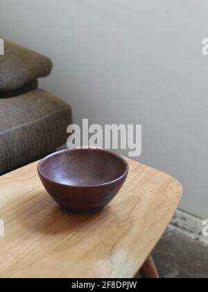 Brown bowl on the bright wood table beside the sofa Stock Photo