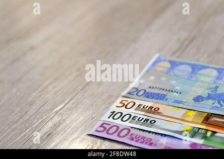 Euro banknotes in a row. Wood background. Stock Photo