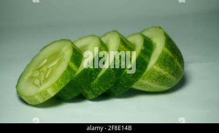 sliced cucumber on white background. preparing salad with cucumber. Stock Photo