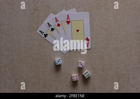 Four cards forming poker of aces and dice on the table. Stock Photo