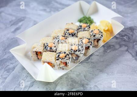 Delivered set of sushi in paper eco container. Lunchtime on workspace. Sushi To Go concept. Top view Stock Photo
