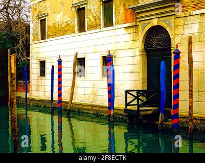 Image of a Stone House with Red and Blue Striped docking poles on a Venice canal at Rio Trasti in the Cannaregio District of Venice. Stock Photo