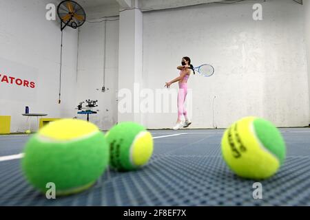 New pink racket and ball in action at green tennis court Stock Photo