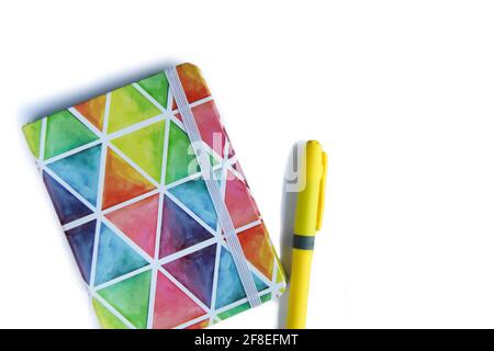 Colorful notebook with pen on white background. Rainbow colors. Stock Photo