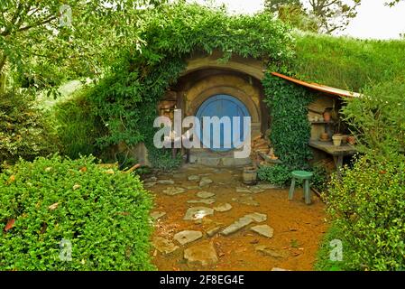 In the heart of Hamilton & Waikato’s countryside, quietly hidden behind green rolling hills, is a place unlike any other – Hobbiton Movie Set; the per Stock Photo