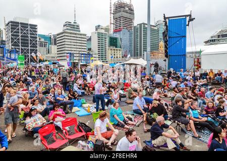 A large crowd on Captain Cook Wharf in the Port of Auckland, New Zelaand, during an open day. In the background is the Auckland skyline Stock Photo