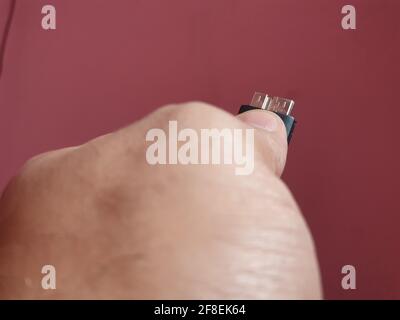 IDE PATA SATA and SCSI Hard Disk cable and pin holdup by a hand background pink for file transfer in computers Stock Photo