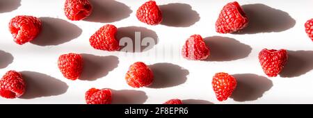 Pattern of fresh raspberry with shadow on light background. Flat lay. Banner. Stock Photo