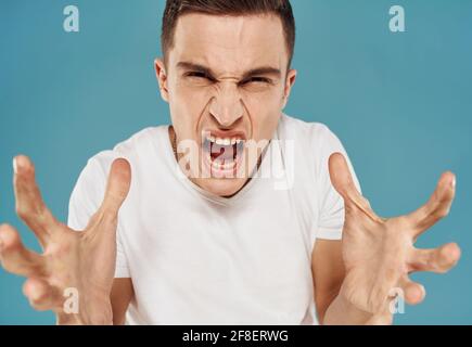 Man gestures with his hands emotions displeasure white t-shirt blue ...