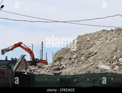 Piles of Gravel at Construction Site. A large powerful loader overloads a pile of rubble in a concrete plant. Stock Photo