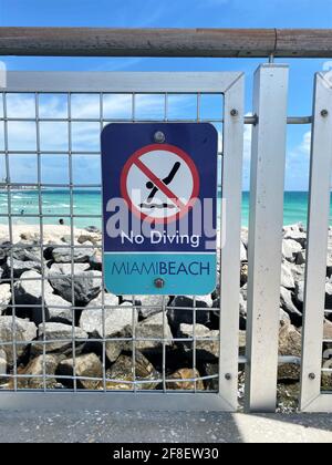 South Pointe Pier in Miami Beach, Florida sign for no diving allowed. Too many rocks and very dangerous. Stock Photo