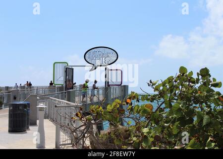 Outside the South Pointe Pier Park in Miami Beach, Florida. People are fishing and exercising on the pier. Stock Photo
