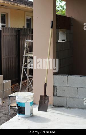 Construction work being performed in a backyard to create a tool shed and pathway in the yard. Painting. Stock Photo