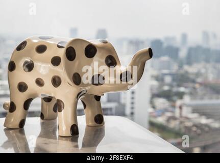 Elephants shaped ceramic on table In living room with city view. Home decor, Copy space, Selective focus. Stock Photo