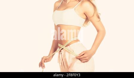 Woman with measuring tape. Weight loss concept. Woman take waist scale tape show her thin waist. Slim girl with centimeter. Closeup woman measuring Stock Photo