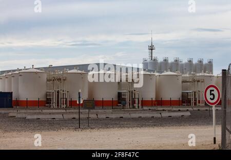 Mangystau, Kazakhstan - May 19 2012: Bautino bay and seaport. Oil loading terminal on Caspian sea. Storage tanks, tower. Blue sky with clouds. Stock Photo