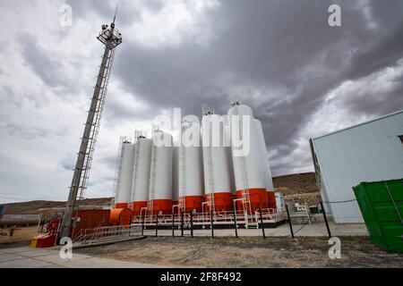Mangystau, Kazakhstan - May 19 2012: Bautino bay. Oil loading terminal on Caspian sea. Warehouse. Storage tanks. Grey storm clouds. Stock Photo