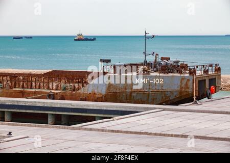Mangystau, Kazakhstan - May 19, 2012: Self-propelled barge on ship terminal. Caspian Sea, Bautino bay, Seaport. Ships in blue water and blue sky. Stock Photo