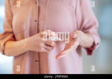 Close up of a woman spraying perfume on her wrist Stock Photo