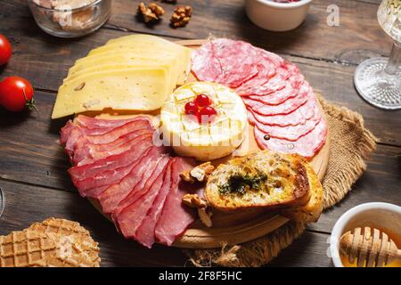 Antipasto platter cold meat with bread, salami, slices ham and cheese on a wooden background Stock Photo