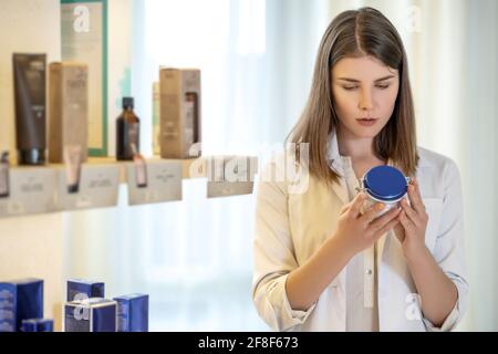 Pretty shop assistant examining new products and looking involved Stock Photo