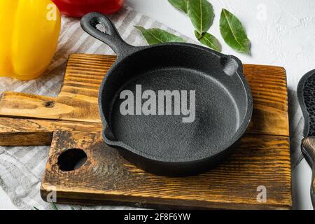 Empty frying cast iron pan background, kitchenware cooking concept, on white stone surface, with copy space for text Stock Photo