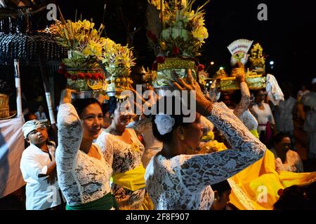 Balinese women carrying temple offerings on their head during a festival in Ubud, Bali, Indonesia. Stock Photo