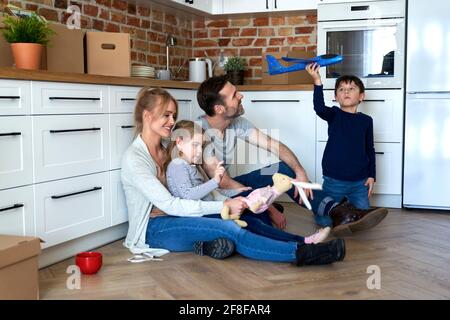 Happy family sitting during moving to a new home Stock Photo