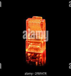 Connector rj-45. Orange transparent connector rj45 for network and internet. Close up macro isolated on black background with reflection. Stock Photo