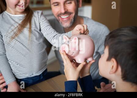 Close up of happy father with children savings money Stock Photo