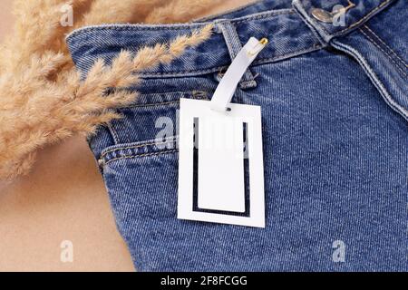 Blank Paper Label Tag On Blue Jeans Stock Photo, Picture and