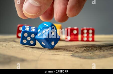 The hand is throwing the blue dices on the map. The concept of board games and a lucky chance to win Stock Photo