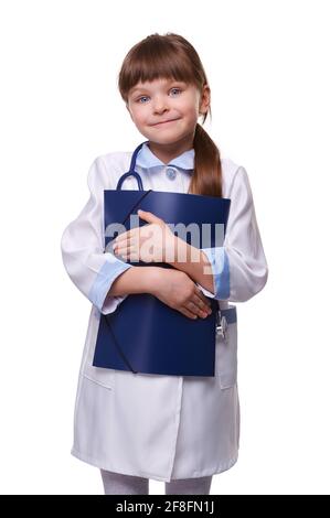 Cute little doctor girl wearing white medical coat with stethoscope holds folder in white isolated background Stock Photo