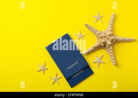 Passports and starfishes on yellow background, top view Stock Photo