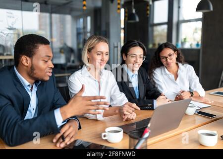 Multicultural Business People Coworkers Discussing Work Project Sitting In Office Stock Photo