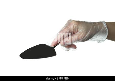 Female hand in disposable glove hold cake spatula, isolated on white background Stock Photo