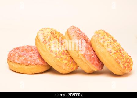 Colourful iced ring doughnuts with sprinkles. Stock Photo