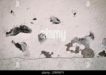 Stucco background, old stone wall with cracks and spots of peeled stucco. Dark sepia tones processing Stock Photo