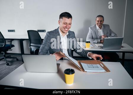 Cheerful business colleagues working on project in office Stock Photo