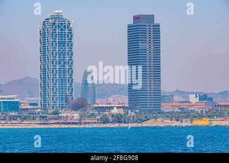 Twin towers standing over Barceloneta beach in Barcelona, Spain Stock Photo