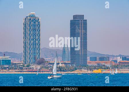 Twin towers standing over Barceloneta beach in Barcelona, Spain Stock Photo