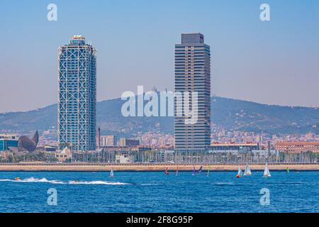 Twin towers standing over Barceloneta beach in Barcelona, Spain Stock Photo