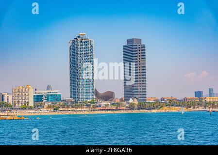 Twin towers standing over Barceloneta beach in Barcelona, Spain Stock Photo