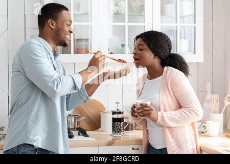 Romantic african american couple cooking healthy food together in kitchen Stock Photo