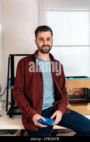 Stock photo of happy young man looking at camera in his 3d printing office. Stock Photo