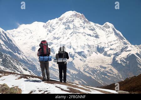 Annapurna south from mount Annapurna base camp with two tourists, Nepal Stock Photo