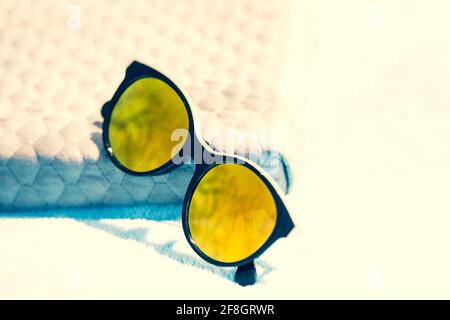 Fashion cat eye sunglasses for ladies with big round yellow lenses and black frame shoot outside in a sunny day closeup. Selective focus  Stock Photo