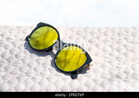 Fashion cat eye sunglasses for ladies with big round yellow lenses and black frame shoot outside in a sunny day closeup. Selective focus  Stock Photo