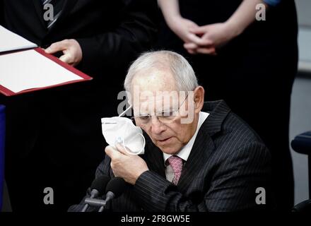 Berlin, Germany. 14th Apr, 2021. Wolfgang Schäuble (CDU), President of the Bundestag, takes off his FFP2 mask at the beginning of the Bundestag session. Credit: Kay Nietfeld/dpa/Alamy Live News Stock Photo